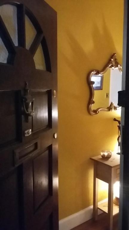 a room with a door and a table with a mirror at Edinburgh TWO BEDROOM apartment with free side street parking 24 hours in Edinburgh