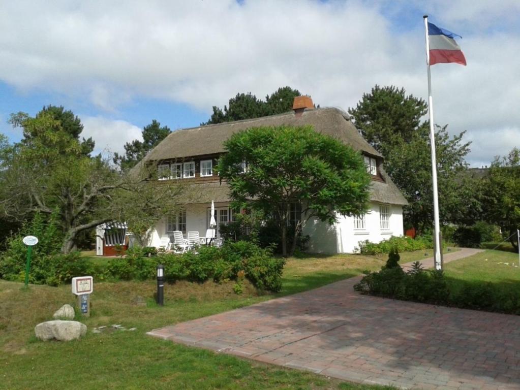 a house with a flag in front of it at Dieksweg in Nieblum