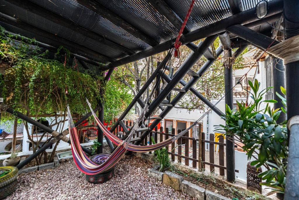 a hammock hanging from a pergola in a garden at Amaka House in Granada