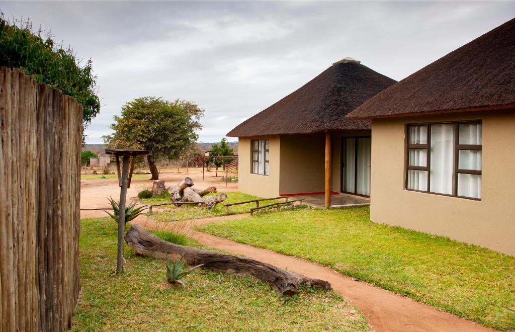Bongan Safari Lodge في Mbabat: منزل فيه بعض الحيوانات جالسه على العشب