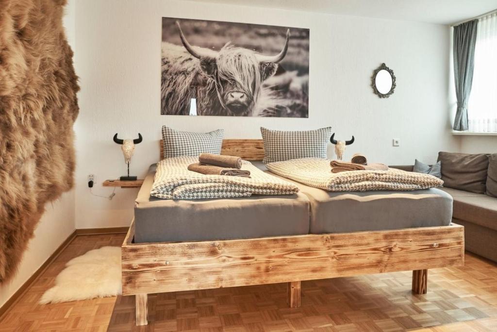 - 2 lits dans une chambre avec un lit à baldaquin pour vache sur le mur dans l'établissement Fewo Helm, à Elsoft