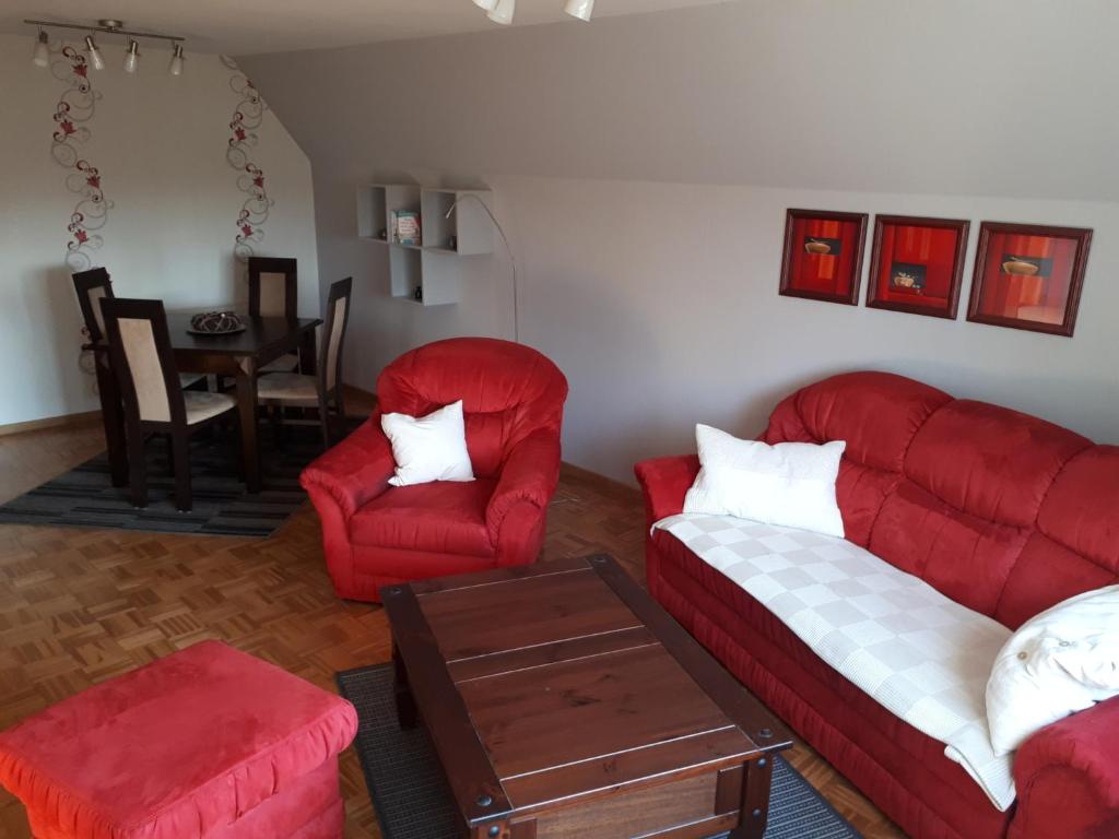 BurgstaakenにあるFewo Pahlke 1291のリビングルーム(赤い椅子2脚、テーブル付)