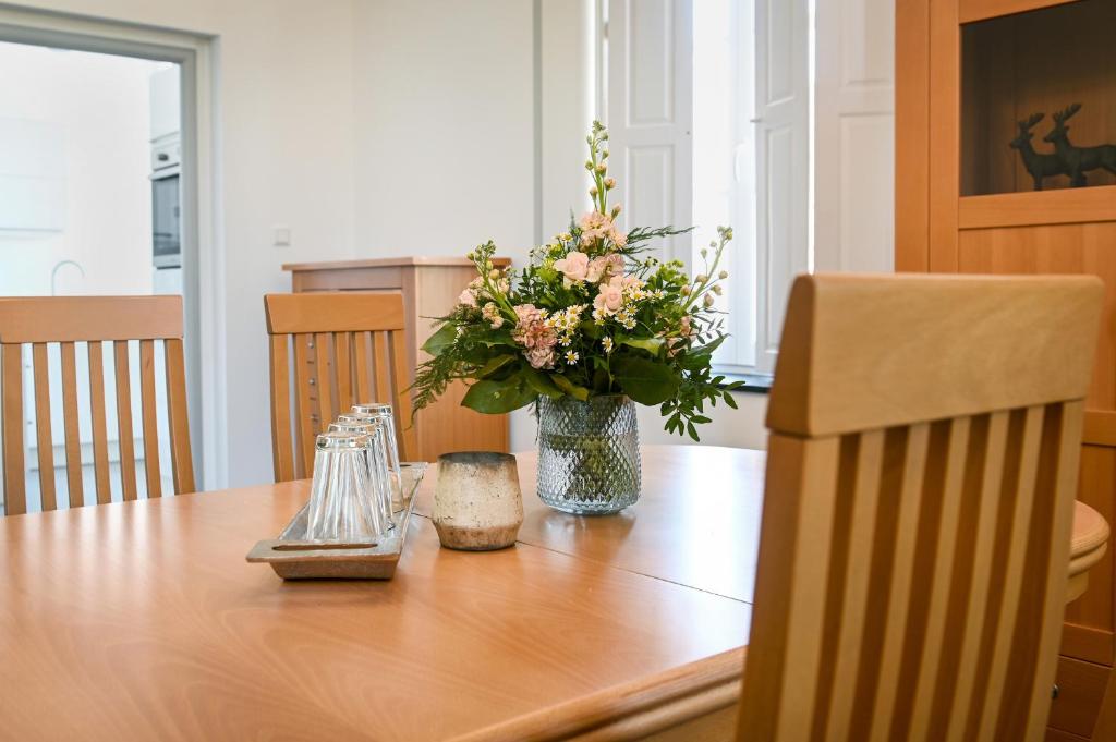 una mesa de madera con un jarrón de flores. en Mühlen-Apartment im Herrenhaus Rheinblick, en Xanten
