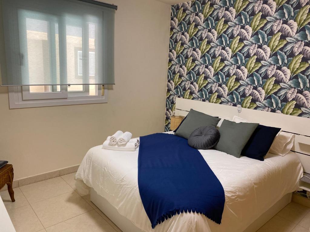 - une chambre avec un lit et une couverture bleue dans l'établissement Apartamento Ro-Ro Valle Gran Rey, à Valle Gran Rey