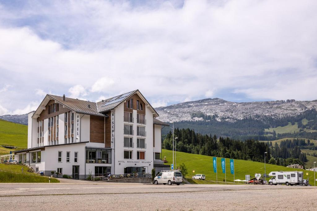 ein Gebäude mit einem Van davor in der Unterkunft Hotel Rischli in Sörenberg