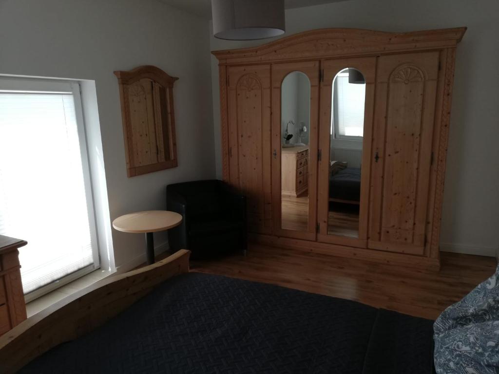 1 dormitorio con un gran armario de madera con espejo en Storchennest, en Raduhn