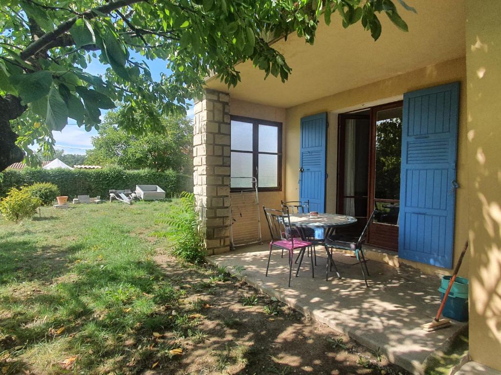 een patio met een tafel en stoelen op een huis bij Appartement les abeillons in Vinon-sur-Verdon