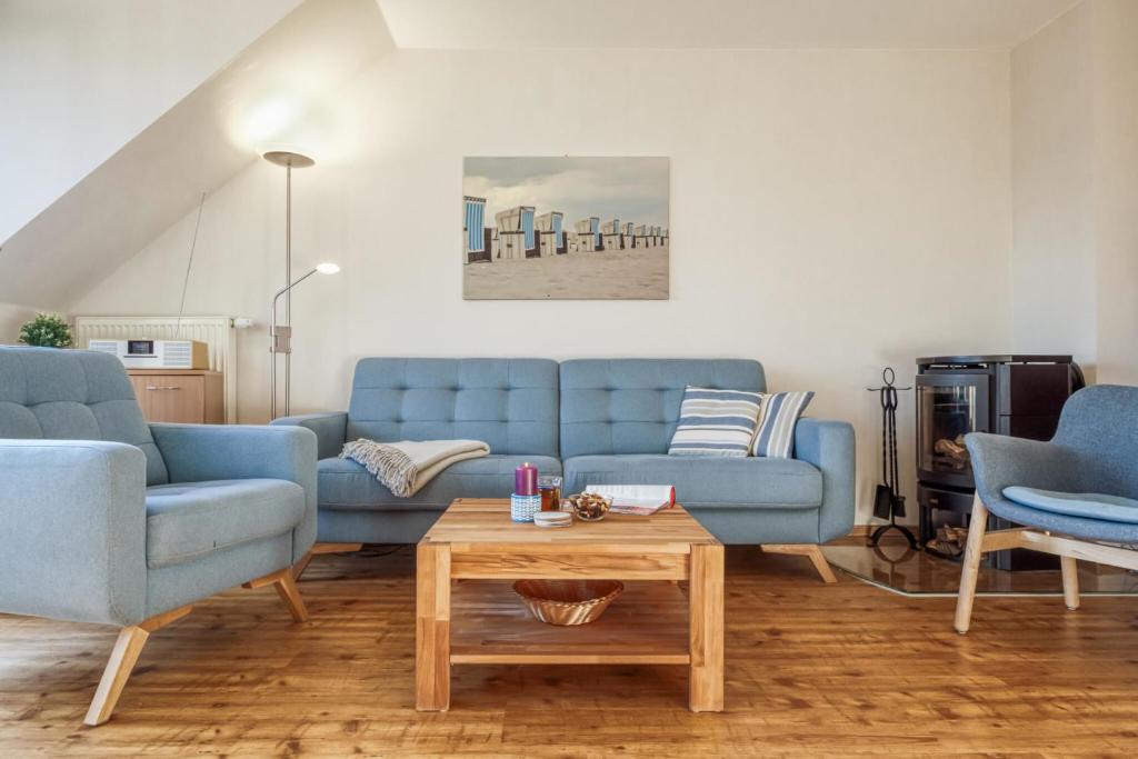 a living room with two blue couches and a coffee table at Sommerwind Whg 3 in Zingst