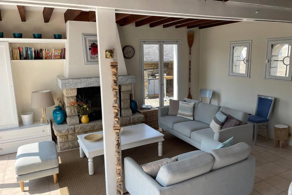 a living room with couches and a fireplace at Maison Golvan centre ville avec parking et jardin in Quiberon