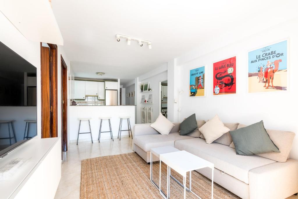 uma sala de estar com um sofá branco e uma cozinha em La Francesa Triana em Sevilha