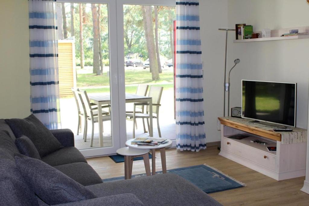 a living room with a couch and a tv and a table at Seeschwalbe App 34 in Dierhagen