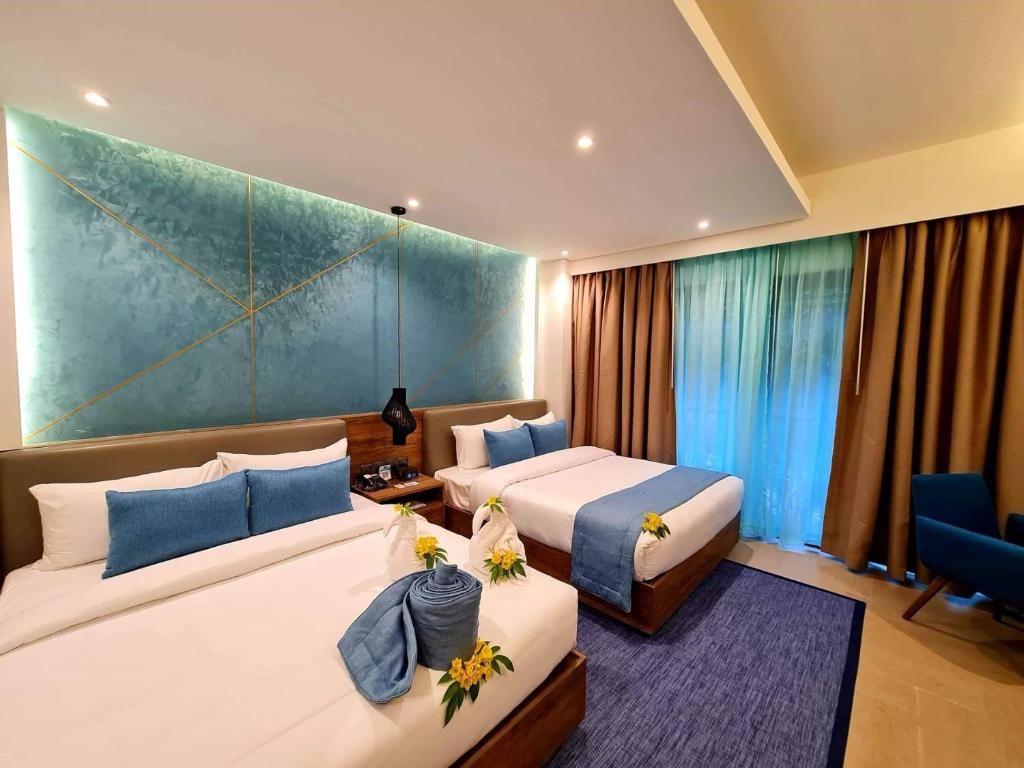 a hotel room with two beds and a blue wall at Fairways and Bluewater Boracay in Boracay