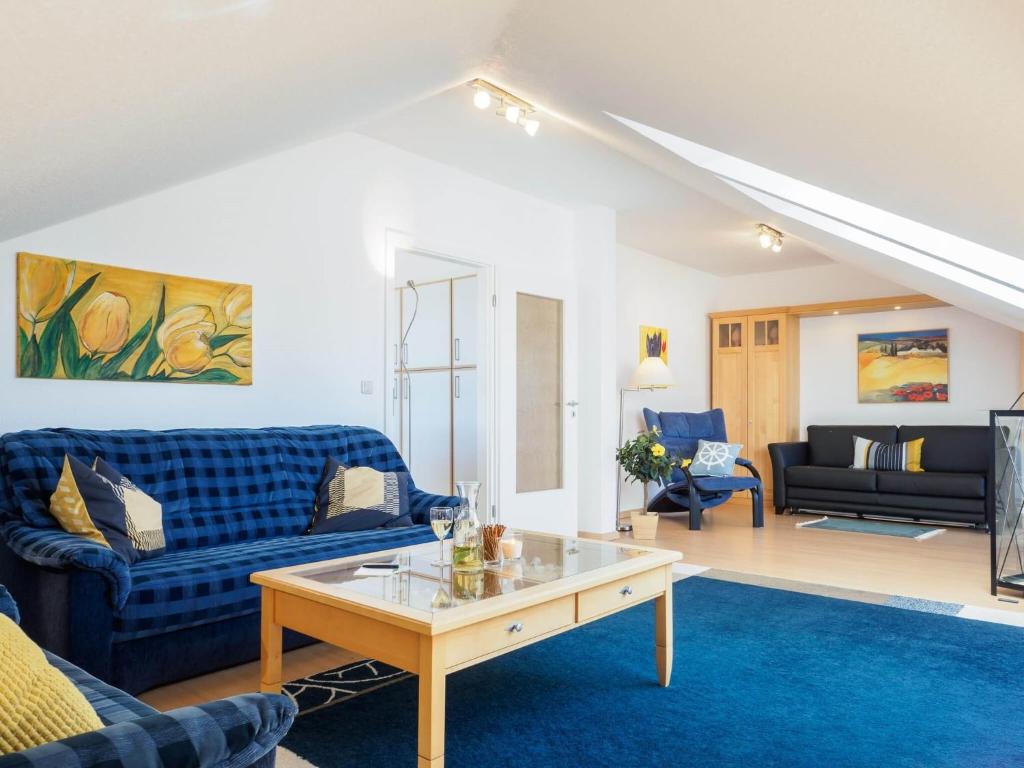 a living room with blue couches and a coffee table at Likedeeler Weg 1 Whg 23 in Zingst