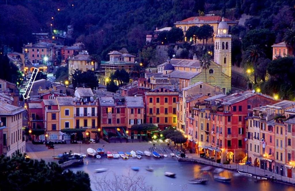 a city at night with boats in a body of water at Appartamento Portofino in Portofino