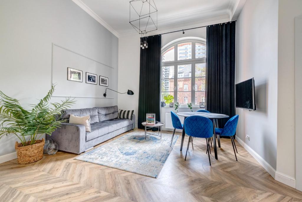 a living room with a couch and a table and chairs at Dom & House - Apartments Waterlane Vintage in Gdańsk