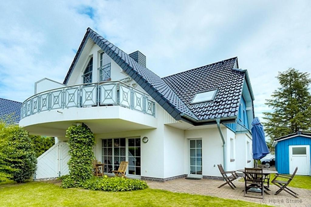 a white house with a blue roof at Lüdtke, Bent in Zingst
