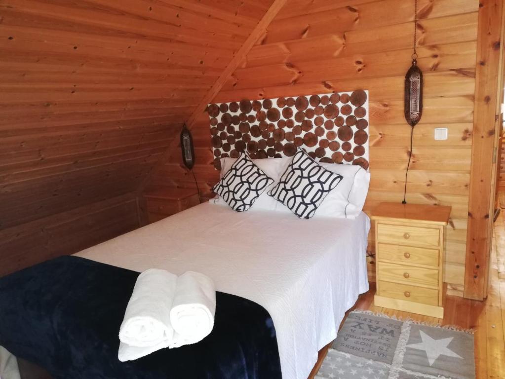 a bedroom with a bed in a wooden cabin at Chalé 41 in Cortes do Meio