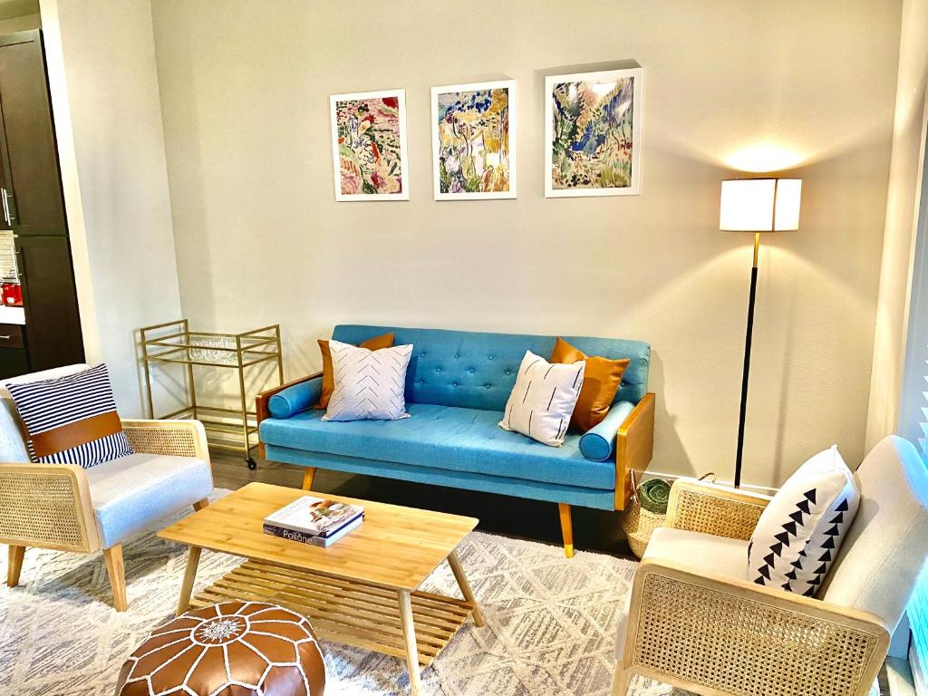 ein Wohnzimmer mit einem blauen Sofa und Stühlen in der Unterkunft Pristine Apt-King Bed-Access to 3 Las Vegas Pools! in Bryan