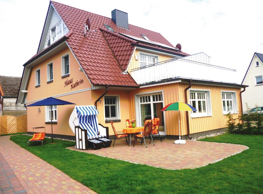 ein Haus mit einer Terrasse mit einem Tisch und Stühlen in der Unterkunft Haus Kathrin in Zingst