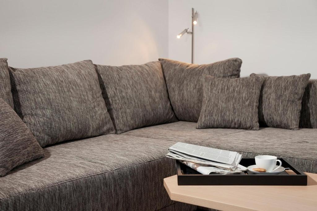 un sofá con almohadas y una bandeja en una mesa en Strandläufer - 29764, en Haffkrug