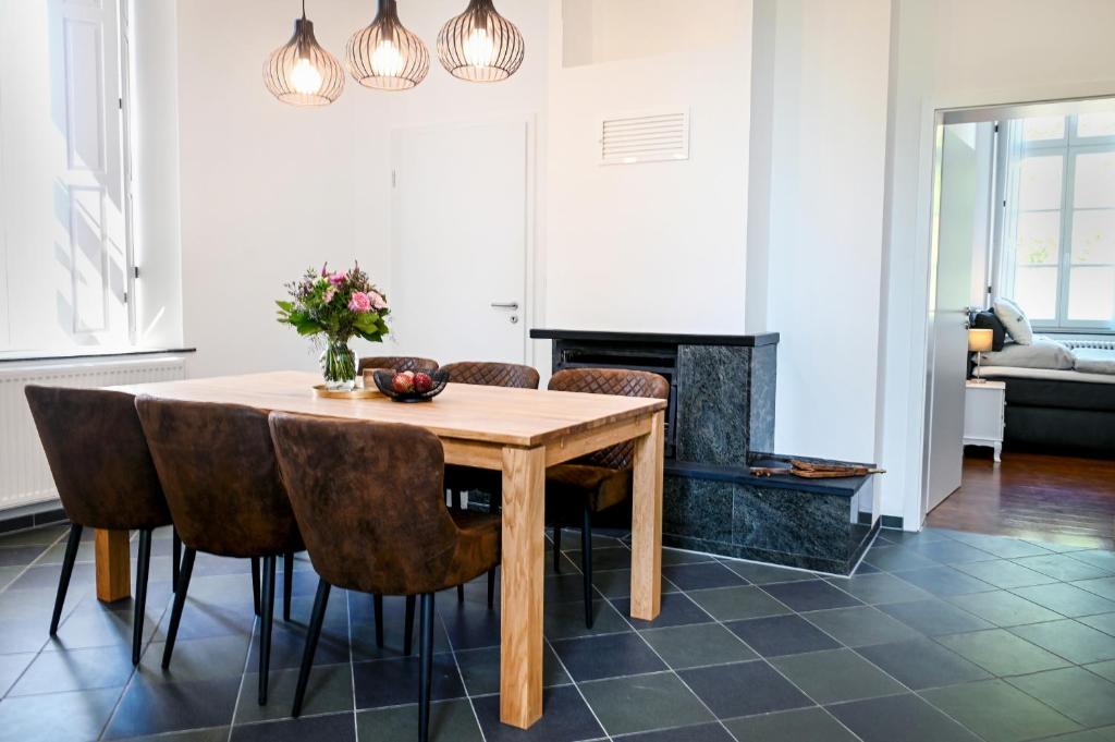 - une salle à manger avec une table et des chaises en bois dans l'établissement Römer-Apartment im Herenhaus Rheinblick, à Xanten