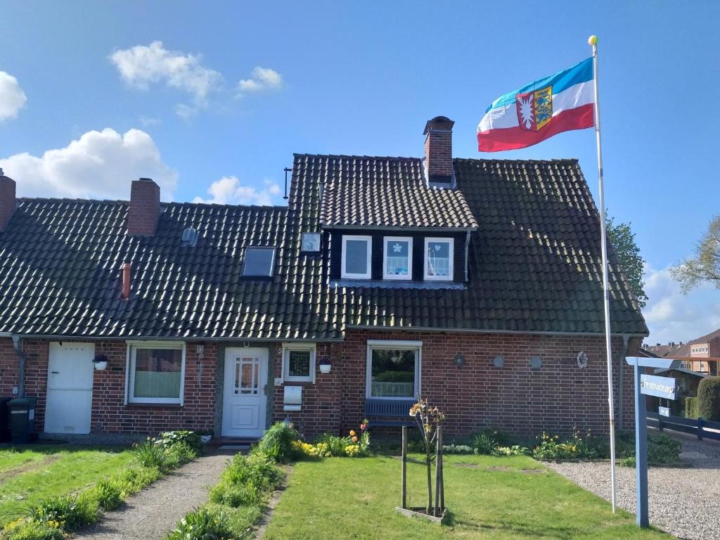 a flag flying in front of a brick house at Ferienwohnung Familie Ruff in Großenbrode