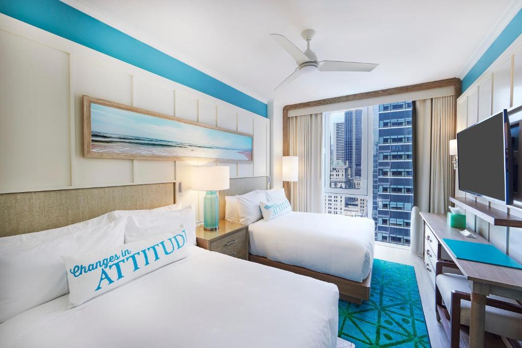 ein Hotelzimmer mit zwei Betten und einem großen Fenster in der Unterkunft Margaritaville Resort Times Square in New York