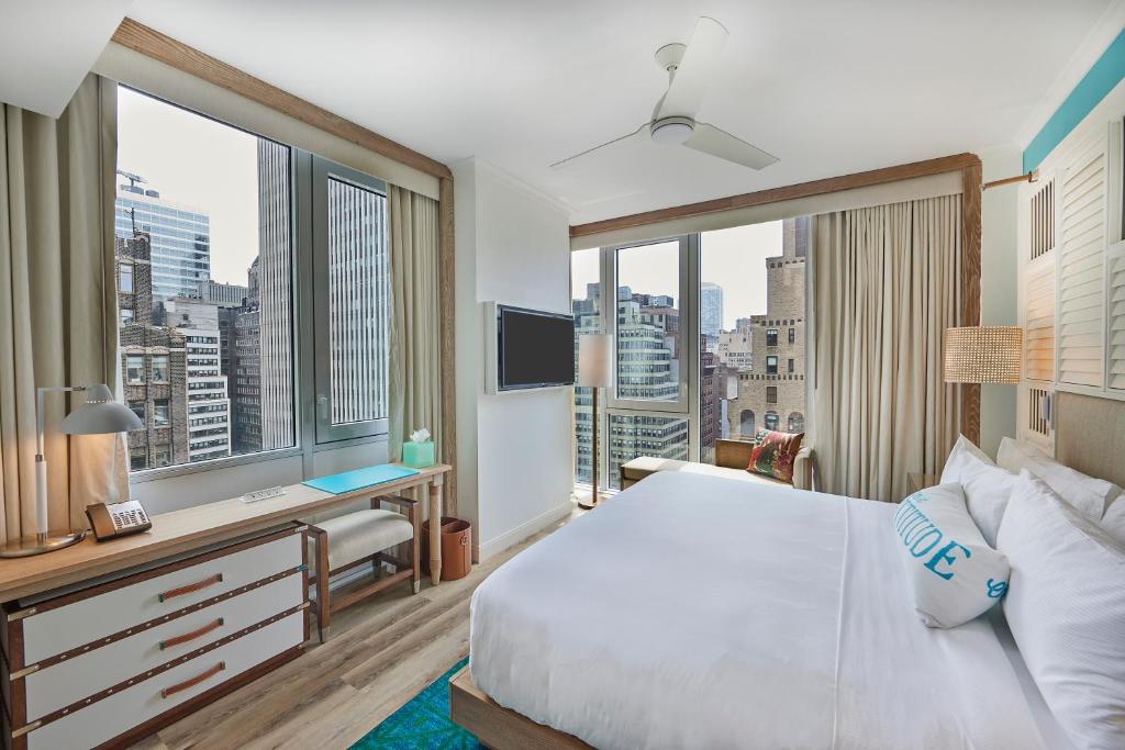 a bedroom with a large bed and large windows at Margaritaville Resort Times Square in New York