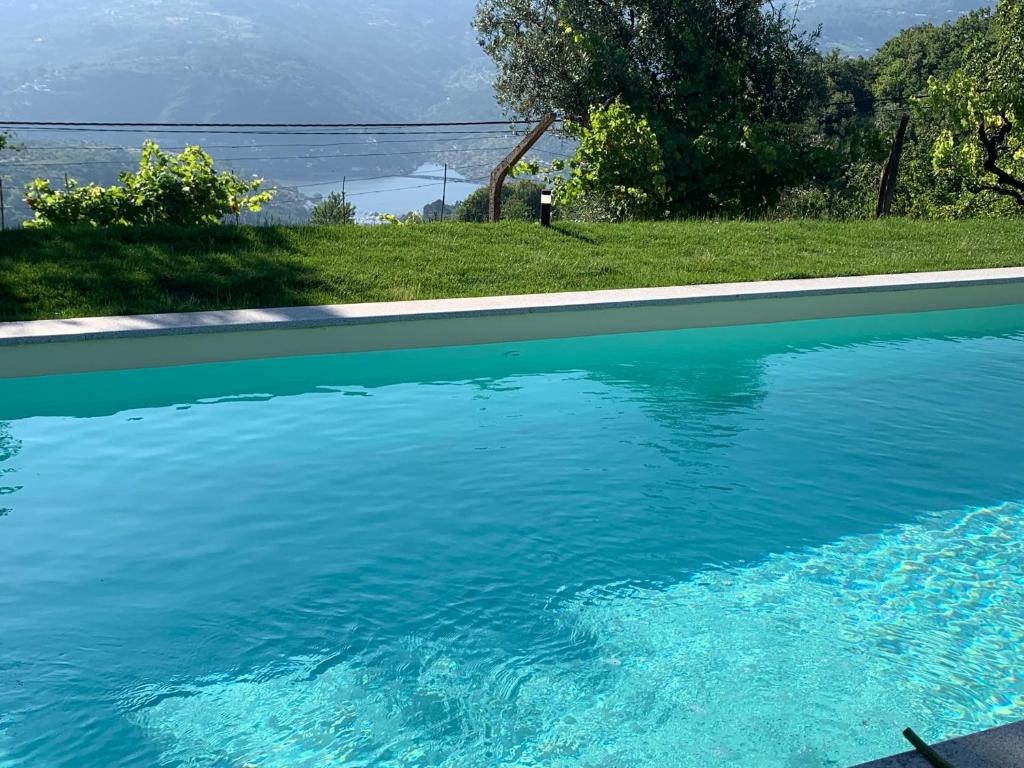 a swimming pool with blue water in a yard at Casa da Horta - Douro Portugal in Bafueiras