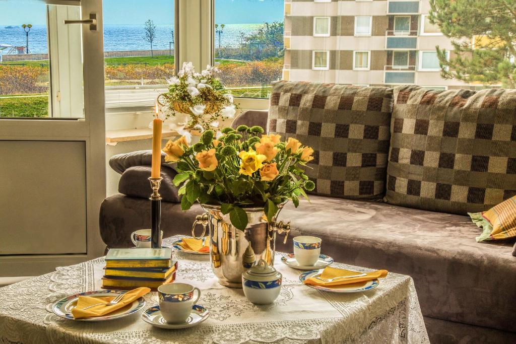 ein Wohnzimmer mit einem Tisch mit gelben Blumen darauf in der Unterkunft FeWo 122, Hanseat II in Grömitz