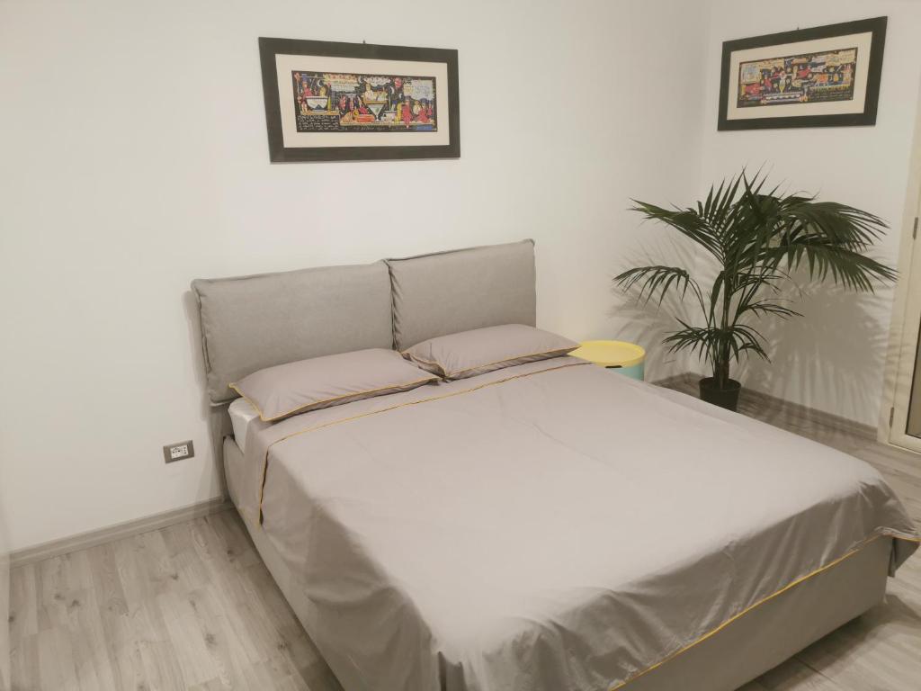 a white bed in a room with a plant at B&B Confort in Reggio Calabria