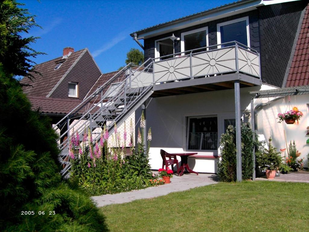 a house with a balcony and a picnic table at DAT OLE FISCHERHUS - App 2 in Heiligenhafen