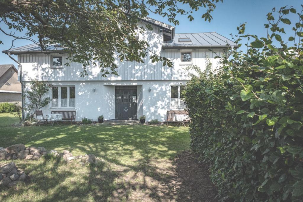 a white house with a yard at FeWo Kranich in Fuhlendorf