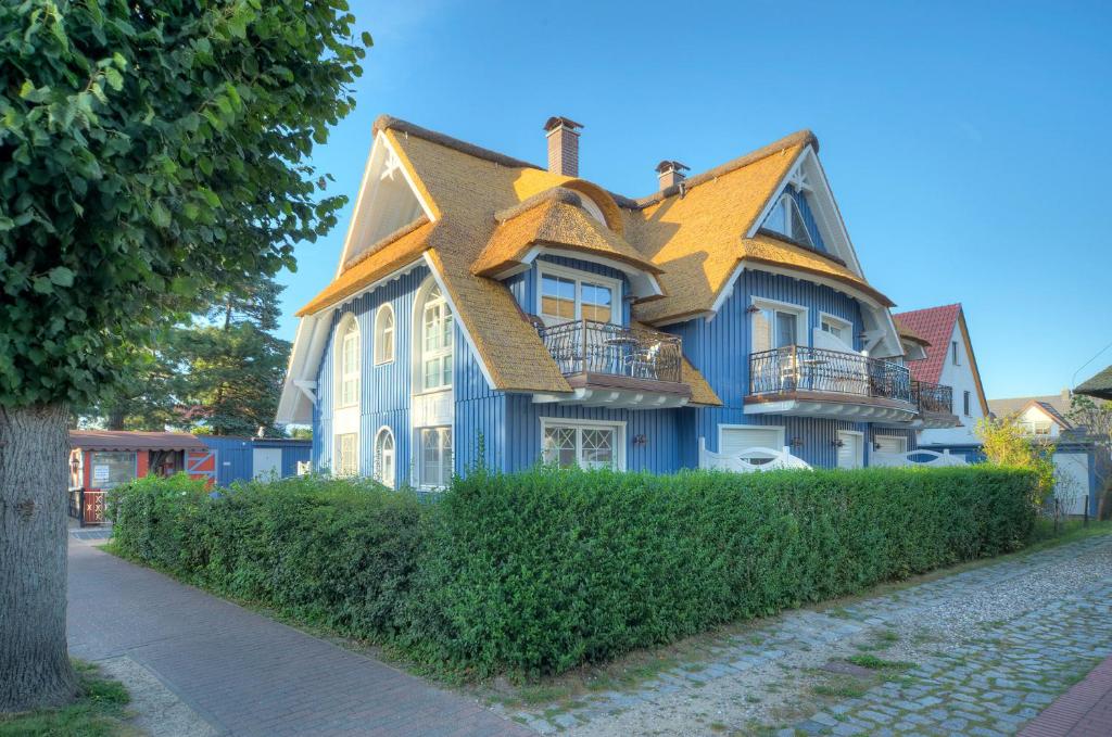 a blue house with a yellow roof at Villa Obendtied, DG-Wohnung "Reet" FW 6 in Zingst