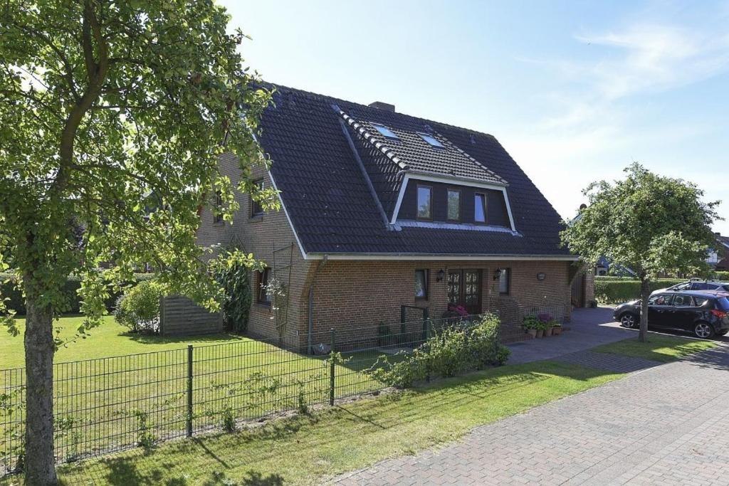 a house with a black roof and a driveway at Schleswig-Holstein Whg 04 OG re in Nieblum