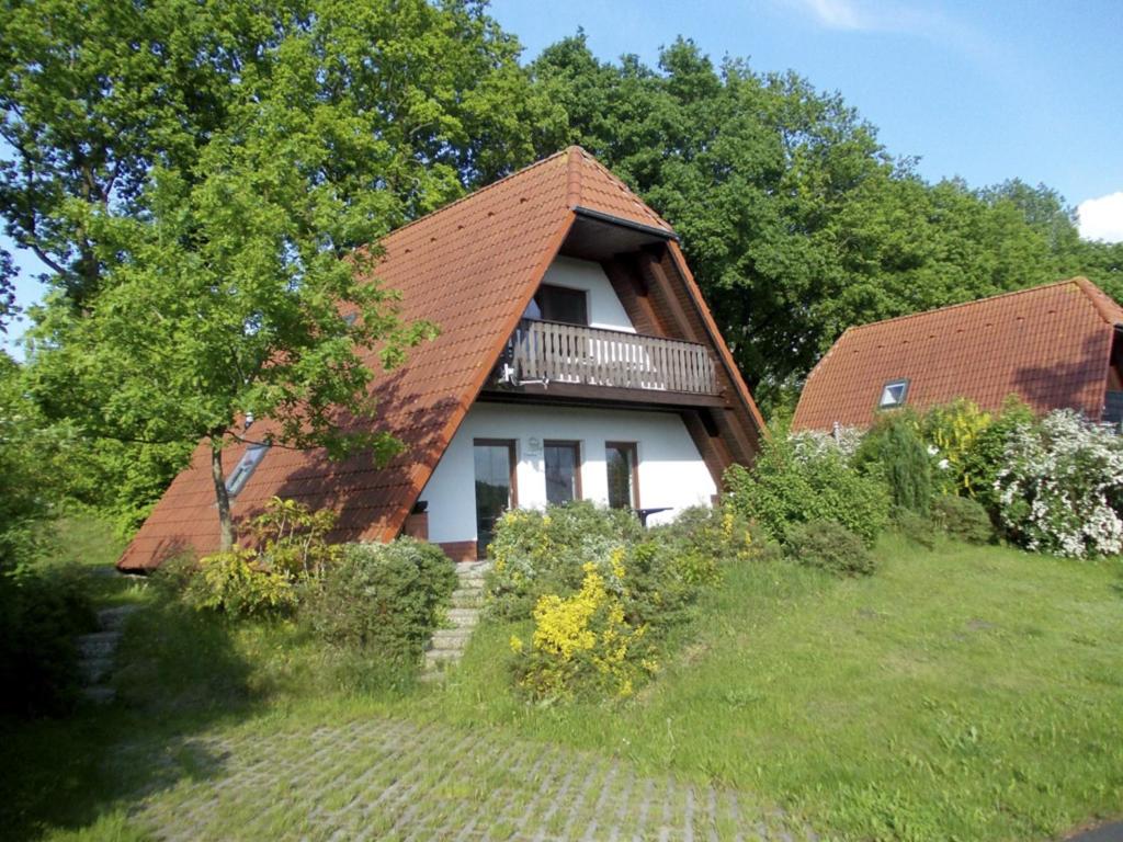 une maison avec un toit marron au-dessus d'une cour dans l'établissement Finnhäuser am Vogelpark - Haus Annika, à Marlow