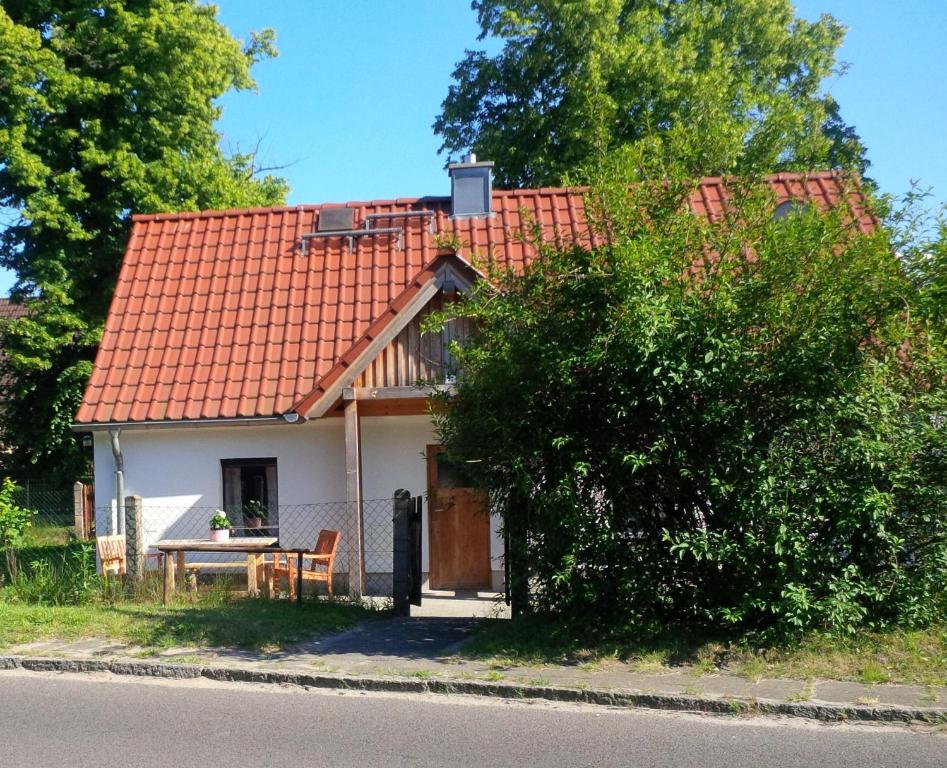 una pequeña casa blanca con techo rojo en Villa Fröhlich en Straupitz