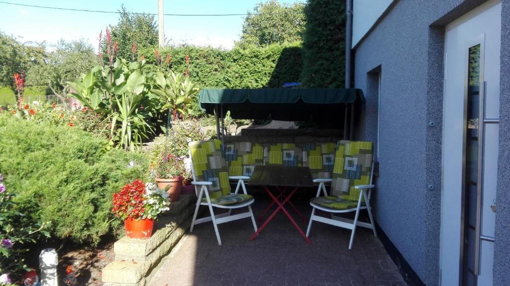 eine Terrasse mit Stühlen und einem Tisch im Garten in der Unterkunft Ferienwohnung Stoll in Brüel
