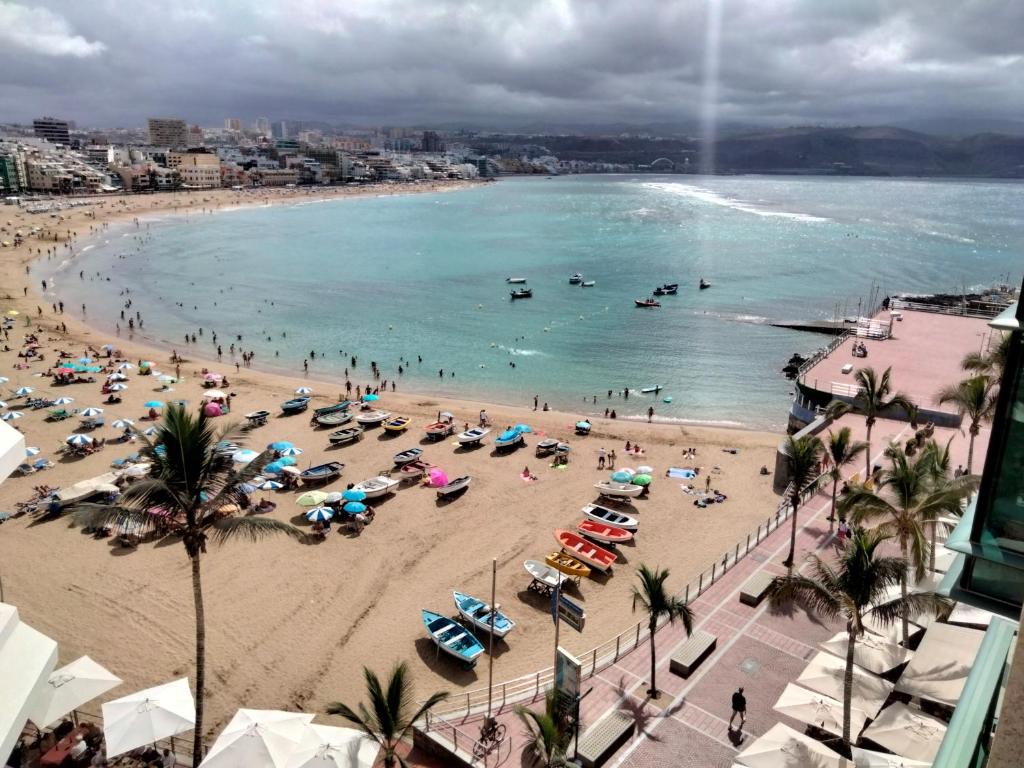 uma praia com um monte de pessoas na água em Apartamento Toñi em Las Palmas de Gran Canaria