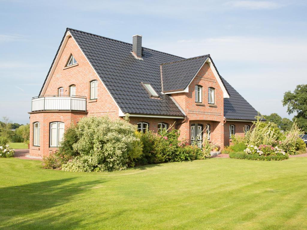 a large brick house with a black roof at Fewo 1 "Landhaus am Grashof" in Offenbüttel