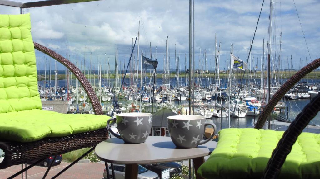 a balcony with two chairs and a view of a marina at Ostsee - Appartement Nr 22 "Ankerplatz" im Strand Resort in Heiligenhafen
