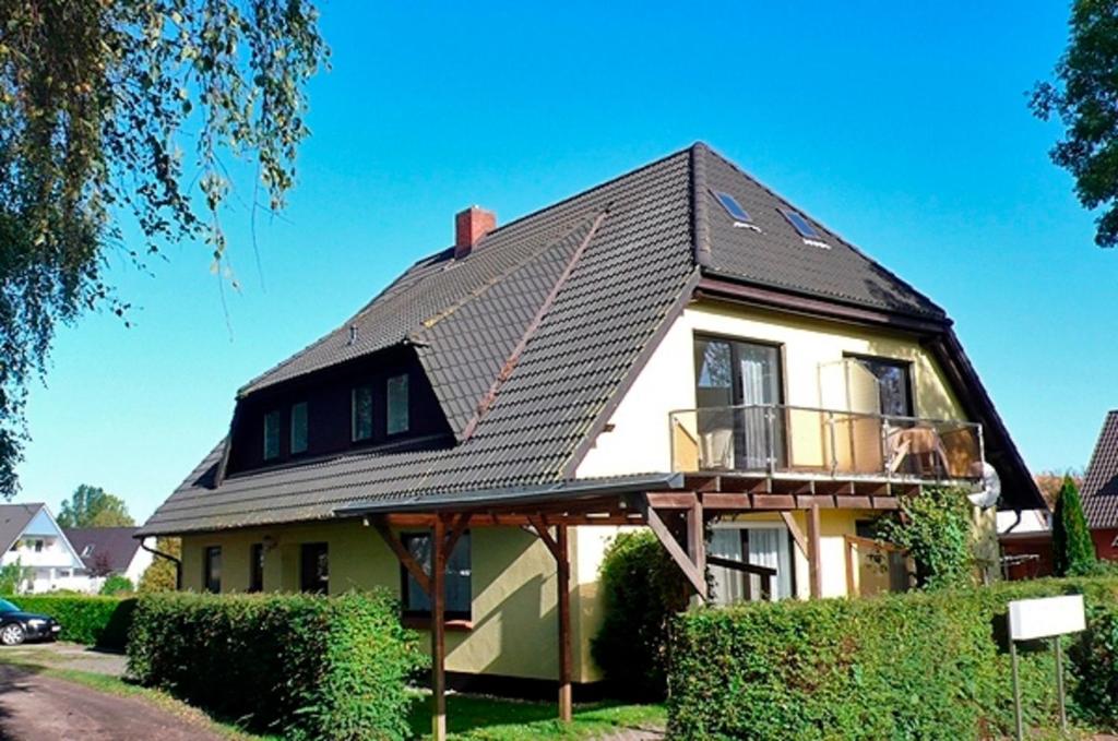ein Haus mit einem schwarzen Dach und einem Balkon in der Unterkunft Wolf, Barbara, FW 3 in Zingst