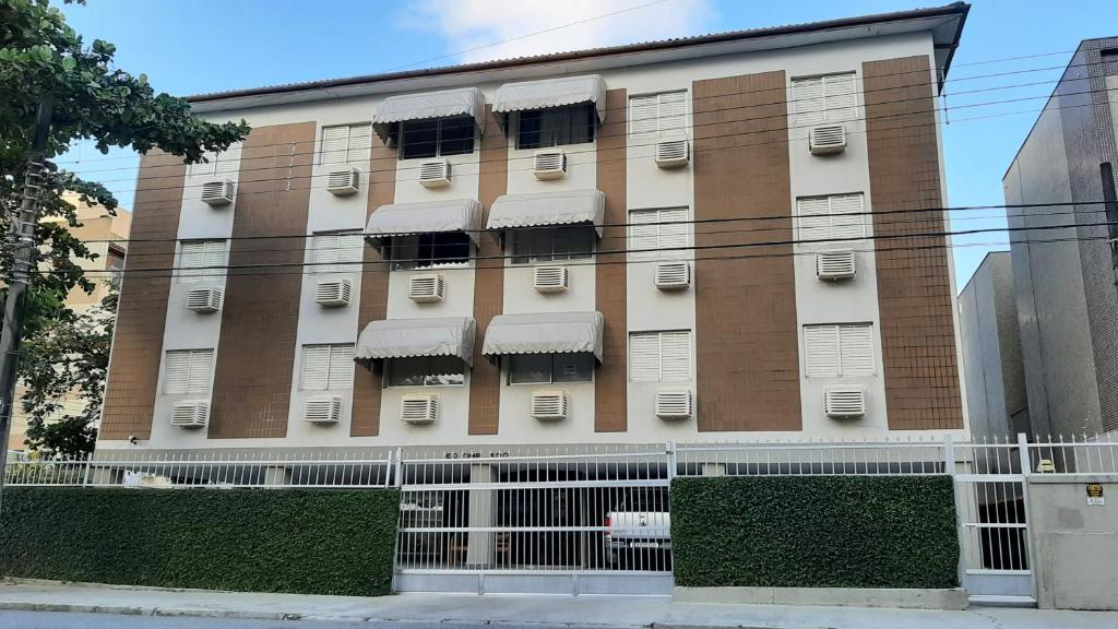 ein hohes Gebäude mit Fenstern und Klimaanlage in der Unterkunft Lindo Apartamento Enseada in Guarujá
