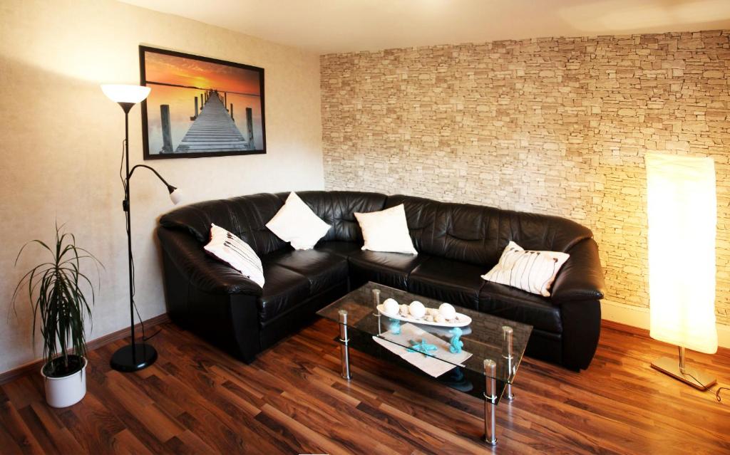 Haus Knoop - Whg 2 في Cismar: غرفة معيشة مع أريكة جلدية وطاولة قهوة