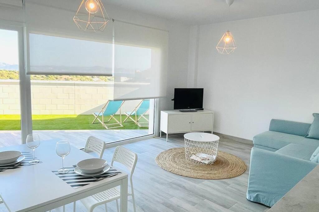 salon z niebieską kanapą i stołem w obiekcie Precioso apartamento con vistas parciales, garaje y piscina w mieście Tarifa