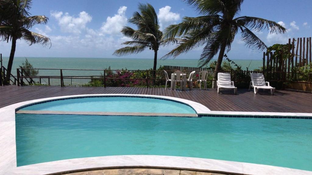 a swimming pool with a view of the ocean at Atlântico Flat 209 in Natal