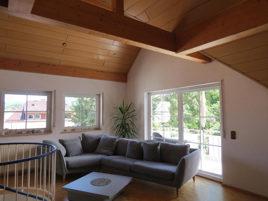 a living room with a couch and two windows at Ferienwohnung am Gässle in Altdorf