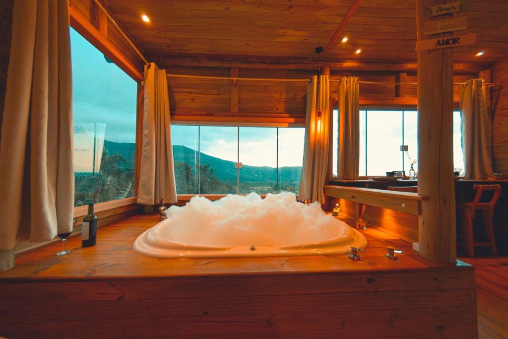 a large bath tub in a room with a window at Pousada Flor de Lótus dos Canyons in Praia Grande