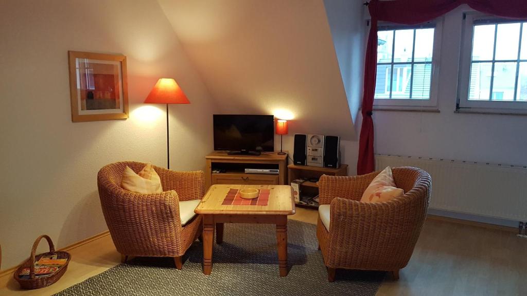 a living room with two chairs and a table and a tv at Birkenstraße 15b App 14 in Zingst