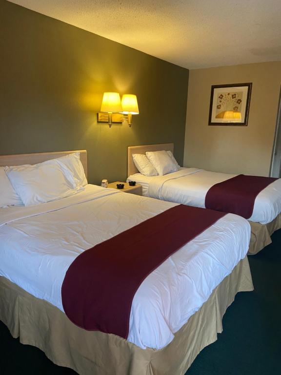 twee bedden in een hotelkamer naast elkaar bij Americas Best Value Inn (Meridian) in Meridian